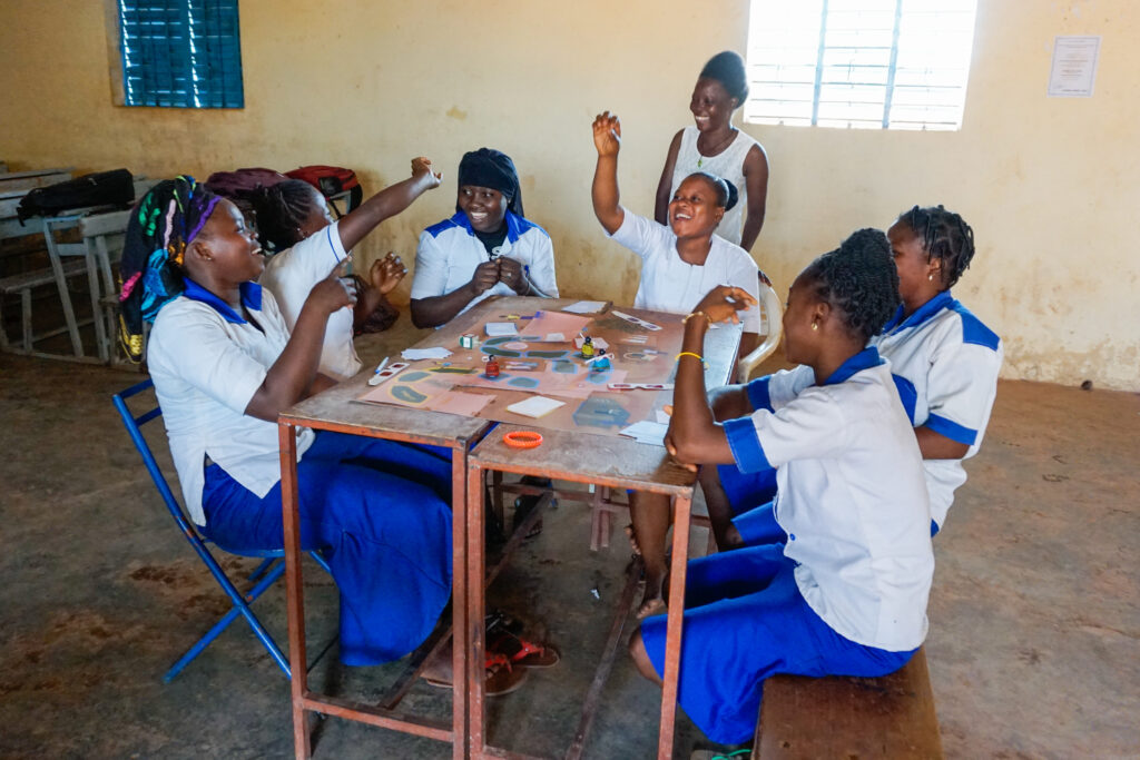 Students play sit at playing a board game