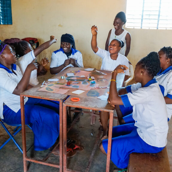 Students play sit at playing a board game
