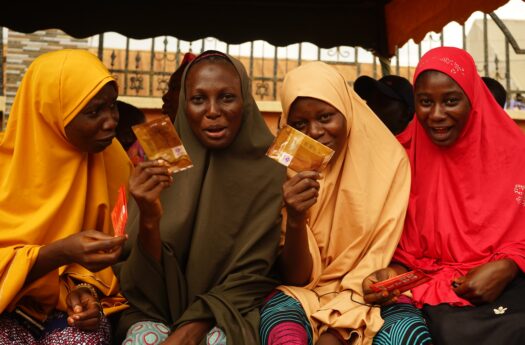 A group of four young girls hold up a female condom