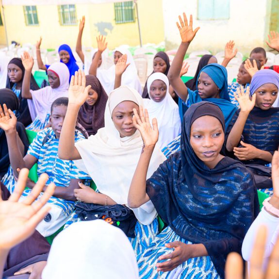 Parents and caregivers attend their children's graduation ceremony. These parents and caregivers formed a "dynamic duo" with their children to reinforce learnings from peer group sessions.
