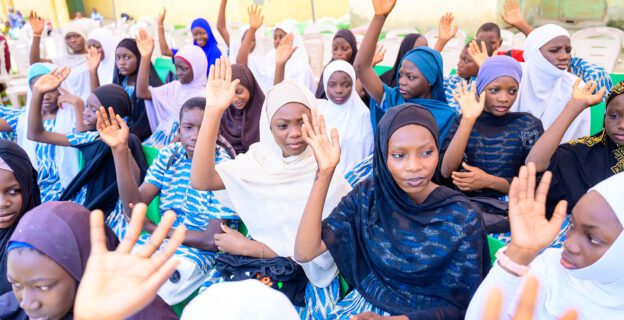 Parents and caregivers attend their children's graduation ceremony. These parents and caregivers formed a "dynamic duo" with their children to reinforce learnings from peer group sessions.